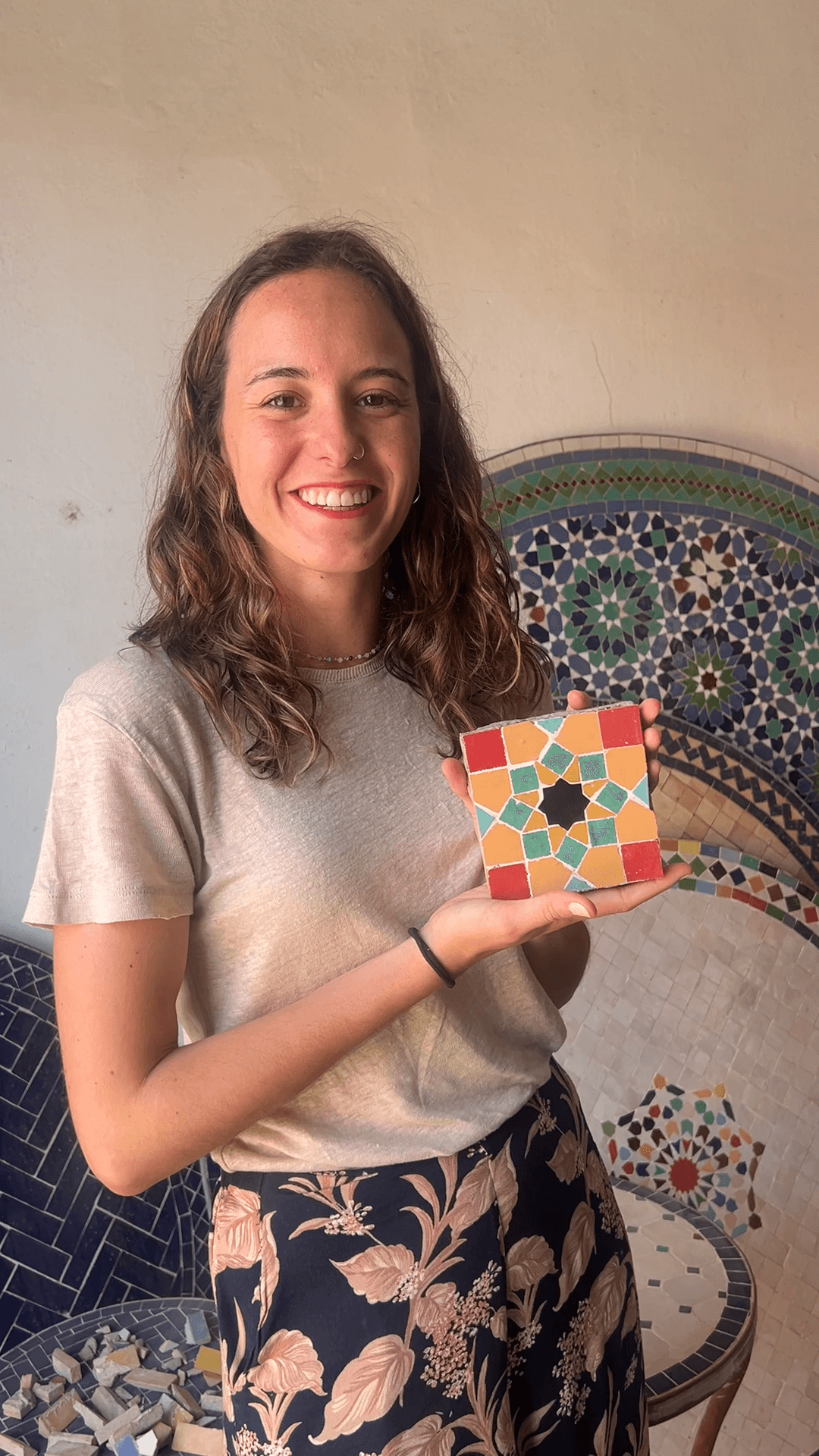 A student holding the zellige tile from a cultural workshop