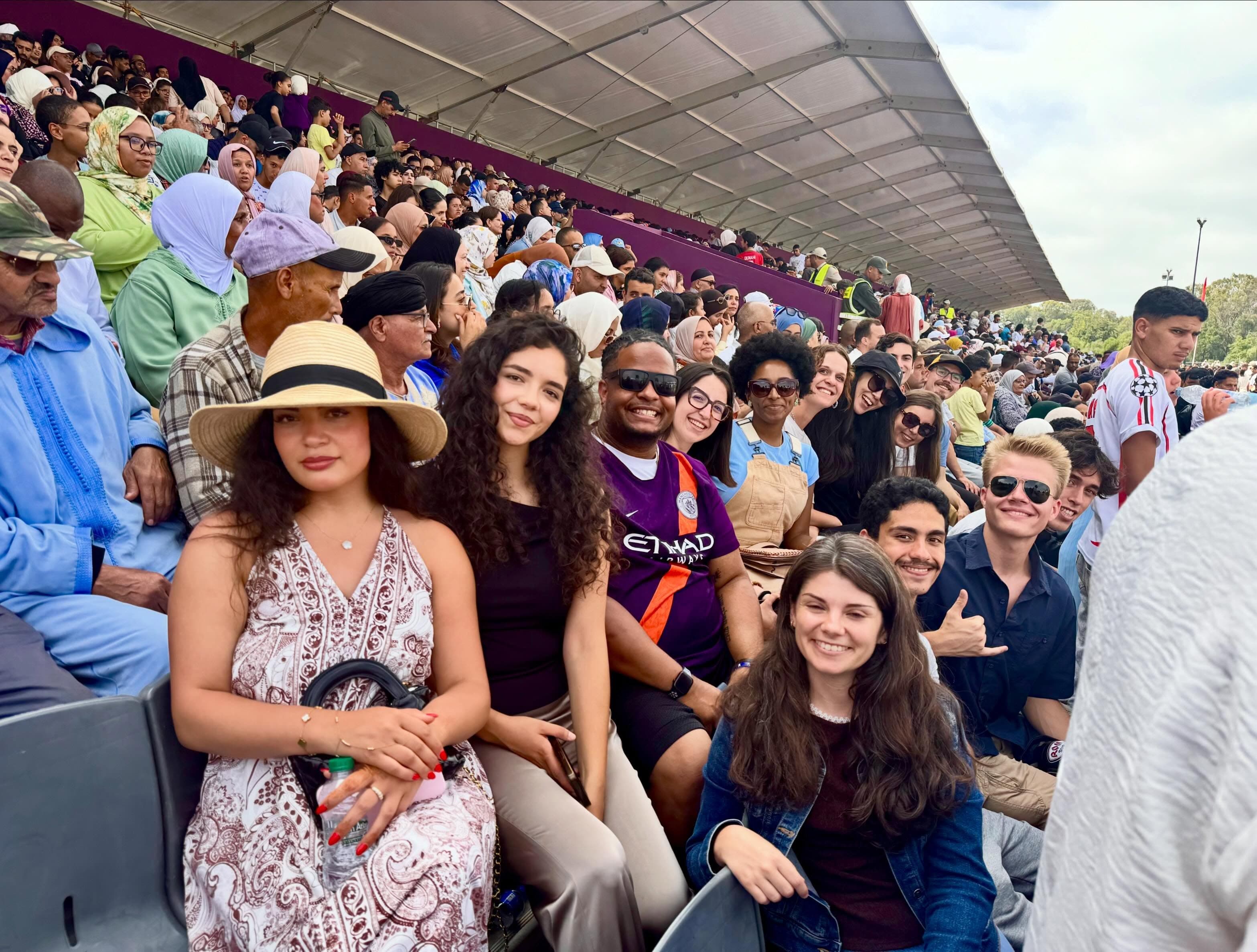 Al Minbar students smiling together in the stands at a public celebration in Morocco